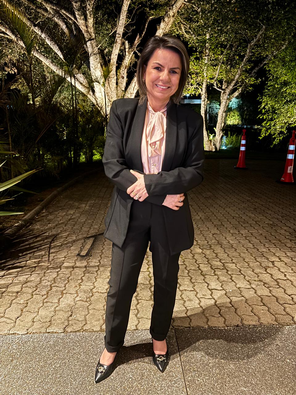 Retrato de Luisa Neves sorrindo em um jardim